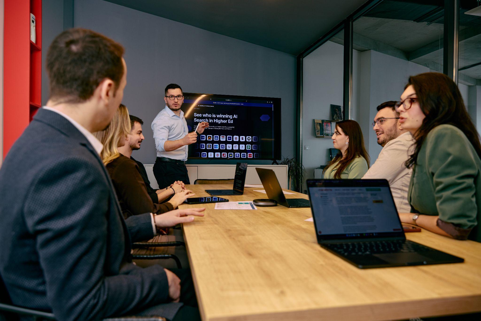 The Manaferra team reviewing an AI search visibility dashboard for higher education during a meeting