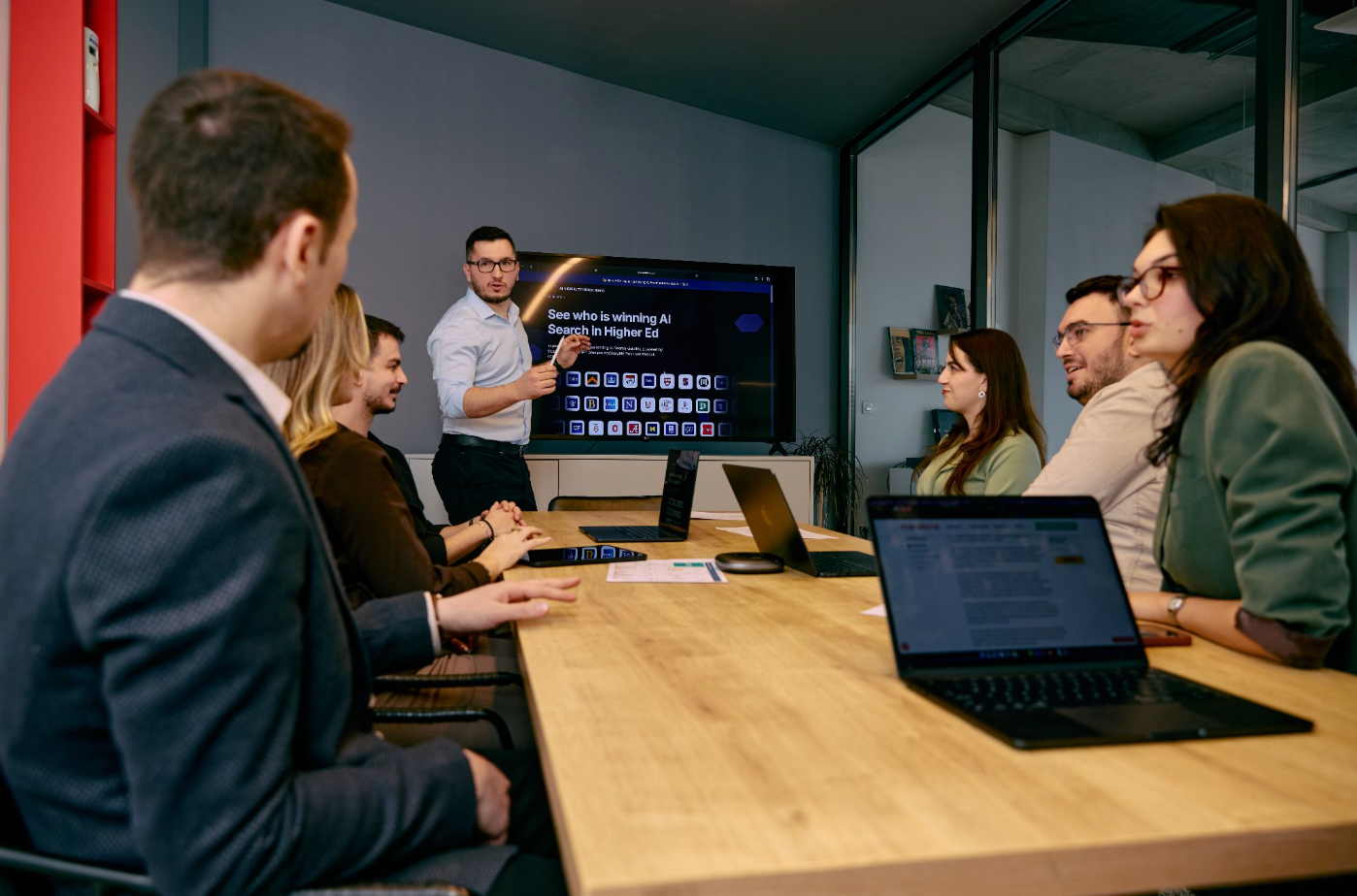 The Manaferra team reviewing an AI search visibility dashboard for higher education during a meeting